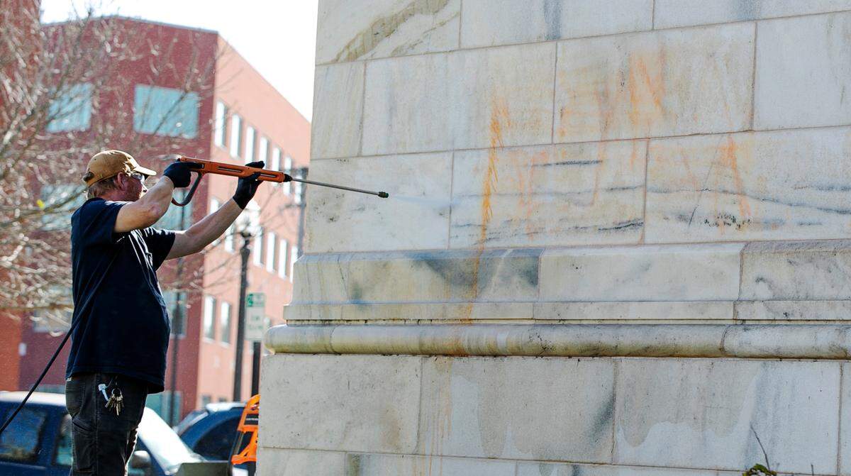 Greg Nihiser, an employee in the Madison County facilities department, uses a power washer to remove “BLM” graffiti from the front of the Madison County Courthouse on Friday in Edwardsville.
