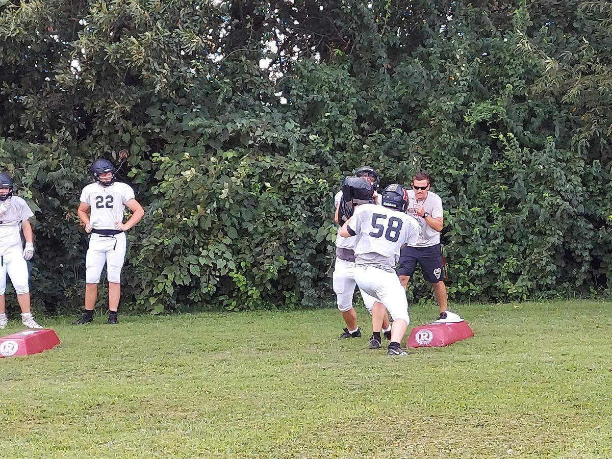 Highland coach Jimmy Warnecke leads the Bulldogs linebackers and defensive linemen through a slide drill during practice Monday, Aug, 15, at Highland High School. Highland is coming off a 2021 season in which it went 5-5 and finished with a first-round IHSA playoff loss to Morton.