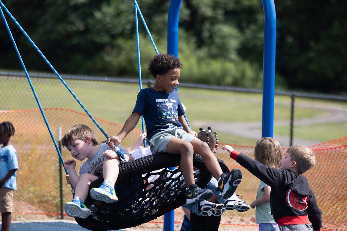 Children play on a saucer-shaped swing in a newly-opened accessible playground in O’Fallon. The swing is considered inclusive because children can use it in various positions; it doesn’t require a child to possess the muscle strength necessary to sit upright like traditional swings do.