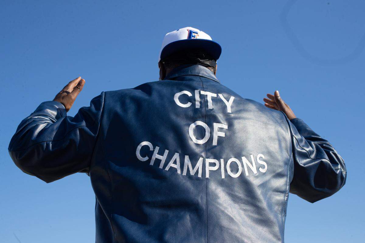 Artagus Williams poses in his “City of Champions” jacket as the East St. Louis victory parade rolls by on State Street.