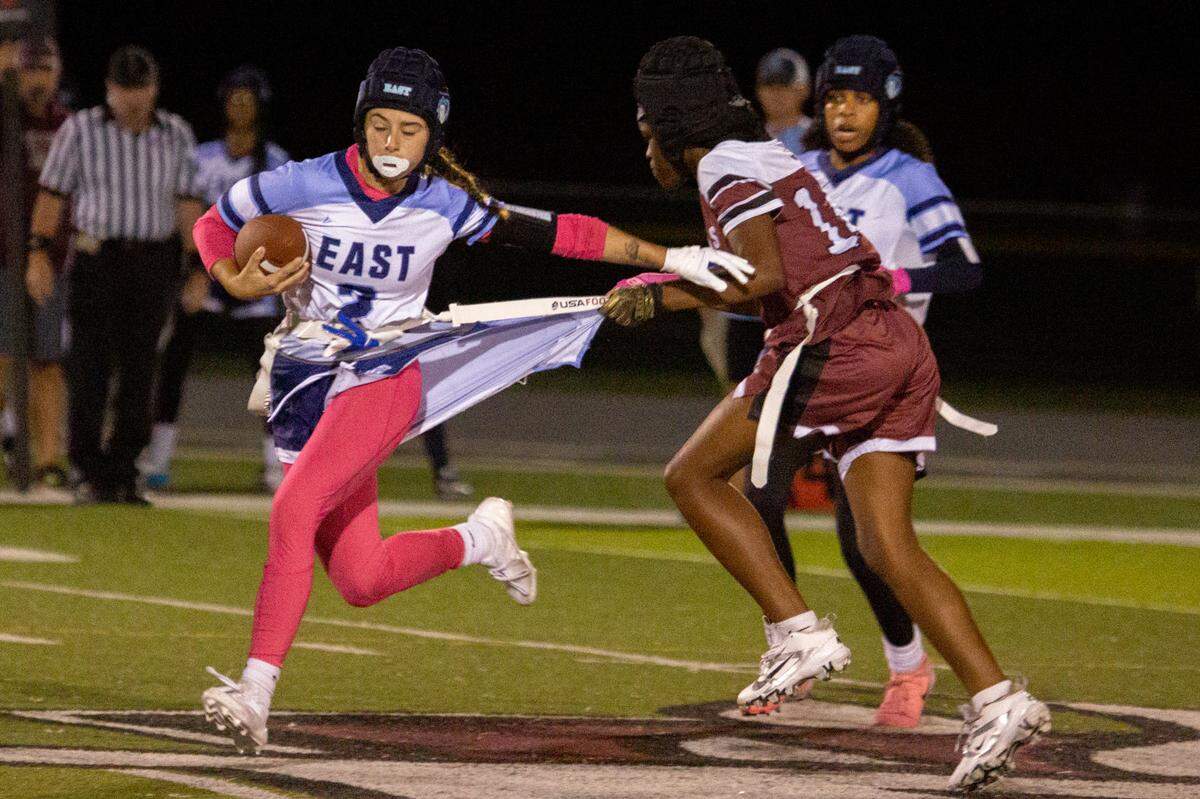 Belleville West’s Kevonna Baker (14) rips off Belleville East’s Ary Kohler (2)’s flag — and shorts — during their final matchup of the season on Wednedsay.