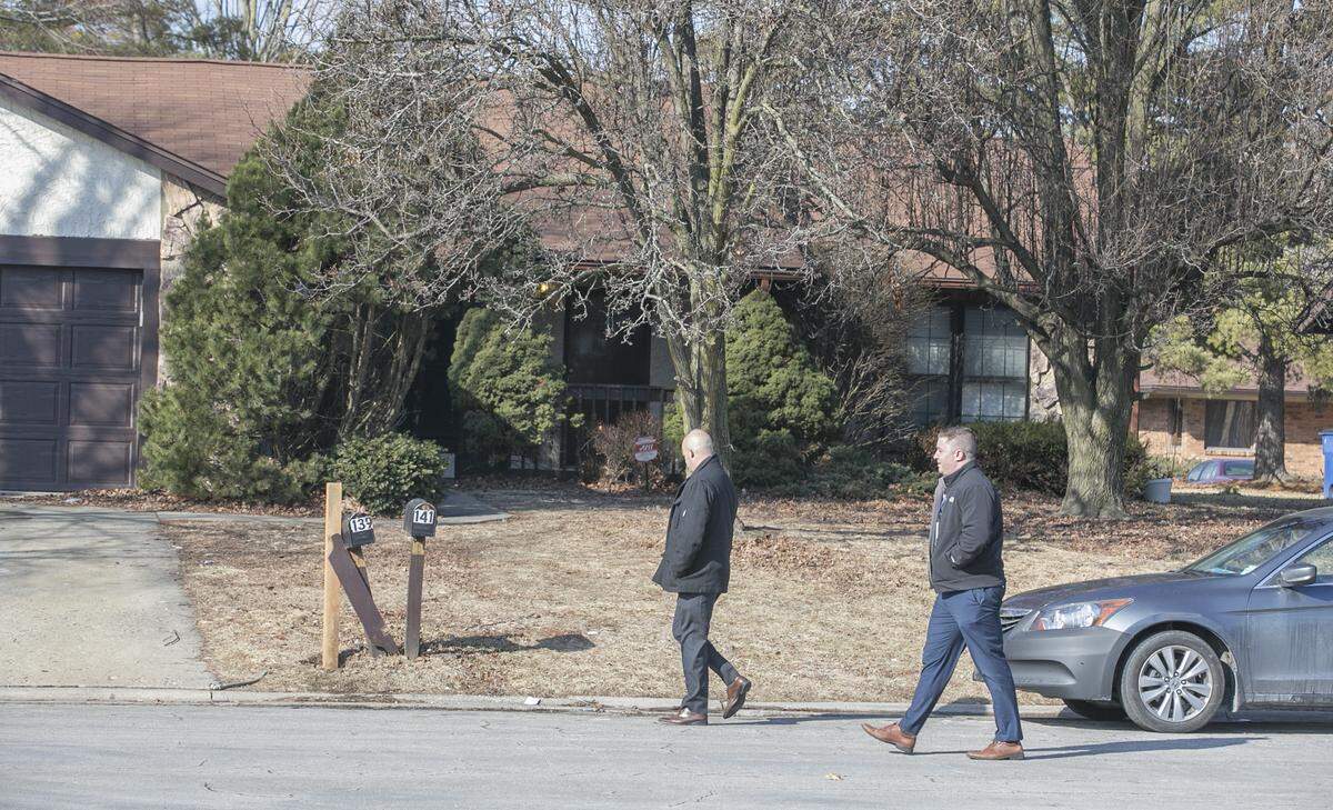 Investigators walk past 141 Paulette Drive in Belleville on Tuesday morning.  The Major Case Squad was activated Monday evening to continue the investigation into  a fatal shooting, which police believe occurred at 141 Paulette Drive in Belleville.
