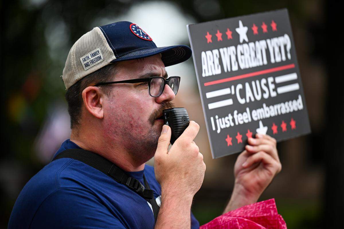 A “No Kings” protester in Belleville chants and holds a sign reading “Are we great yet? ‘Cause I just feel embarrassed,” a reference to President Donald Trump’s “Make America Great Again” campaign slogan.