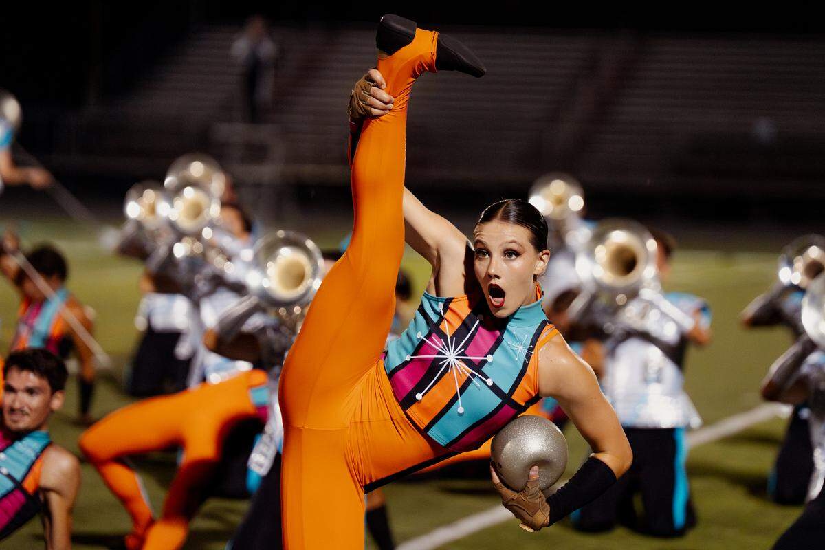 The Boston Crusaders colors guard member reacts while performing their show “BOOM” at Belleville West High School on Tuesday, July 22, 2025, in Belleville.
