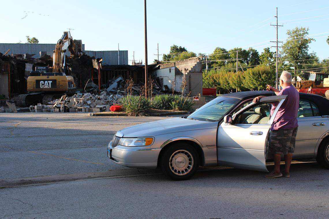 Retiree Dave Stunkel watches from his car Wednesday morning as an excavator demolishes the old Rusty’s Restaurant, which operated in Edwardsville from 1958 to 2008.