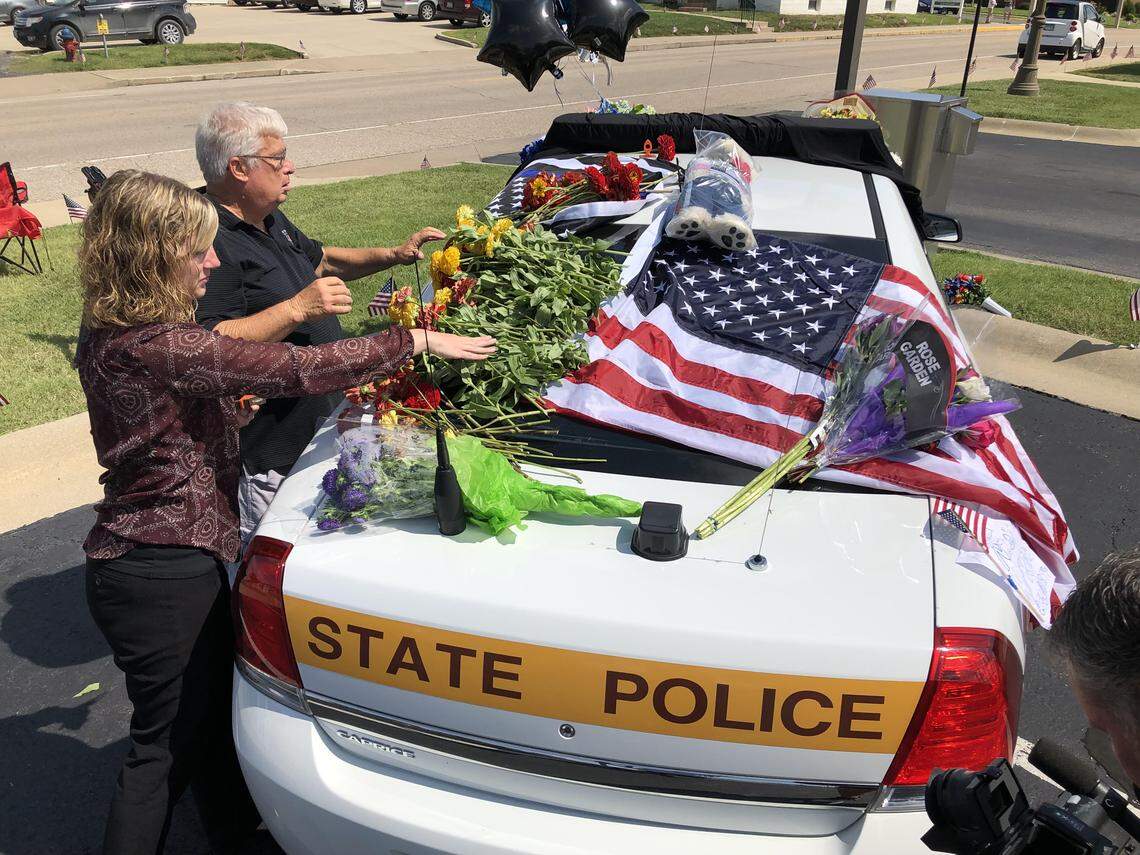 Waterloo Mayor and retired state trooper Tom Smith and city community relations coordinator Sarah Deutch add to the shrine built in the City Hill parking lot to slain Illinois State Trooper Nick Hopkins. Hopkins was killed in East St. Louis Friday while serving a search warrant.