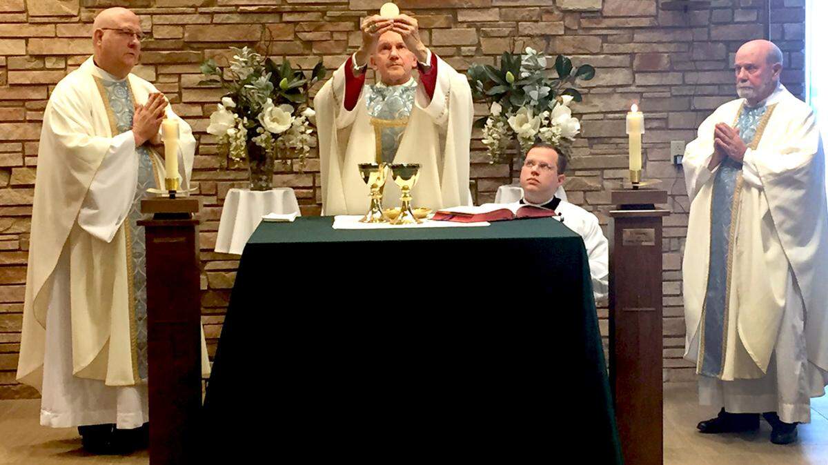 The Most Reverend Thomas John Paprocki (center), bishop of the Diocese of Springfield in Illinois, celebrated Mass on Jan. 26 in HSHS St. Joseph’s Hospital’s Chapel in honor of the 140th anniversary of the Hospital Sisters of St. Francis’ arrival in Highland.  Mass was concelebrated by Father Pat Jakel (left) and Monsignor David Peters (right), with Patrick Hutt, episcopal master of ceremonies for the bishop​ (kneeling).