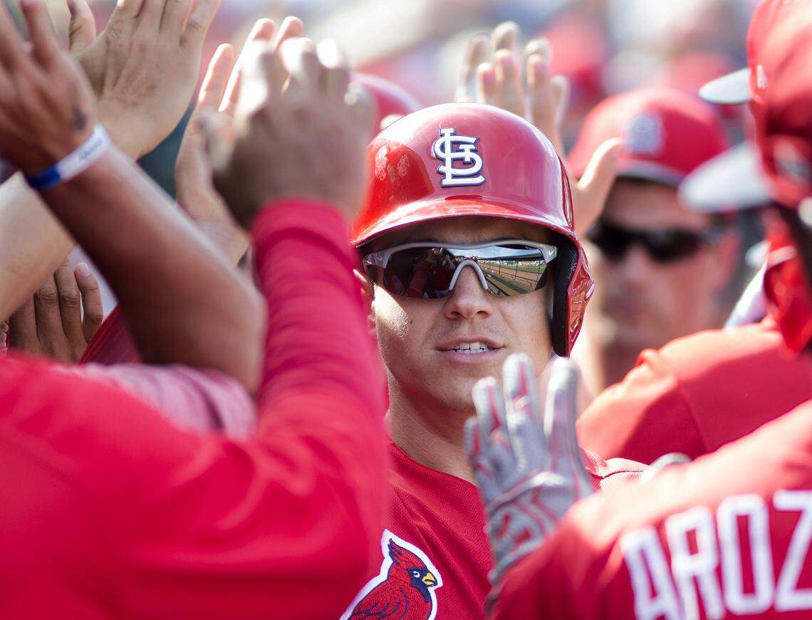 Tyler O'Neill celebrates in the dugout with teammates after scorring during a spring training game in Jupiter, Florida.