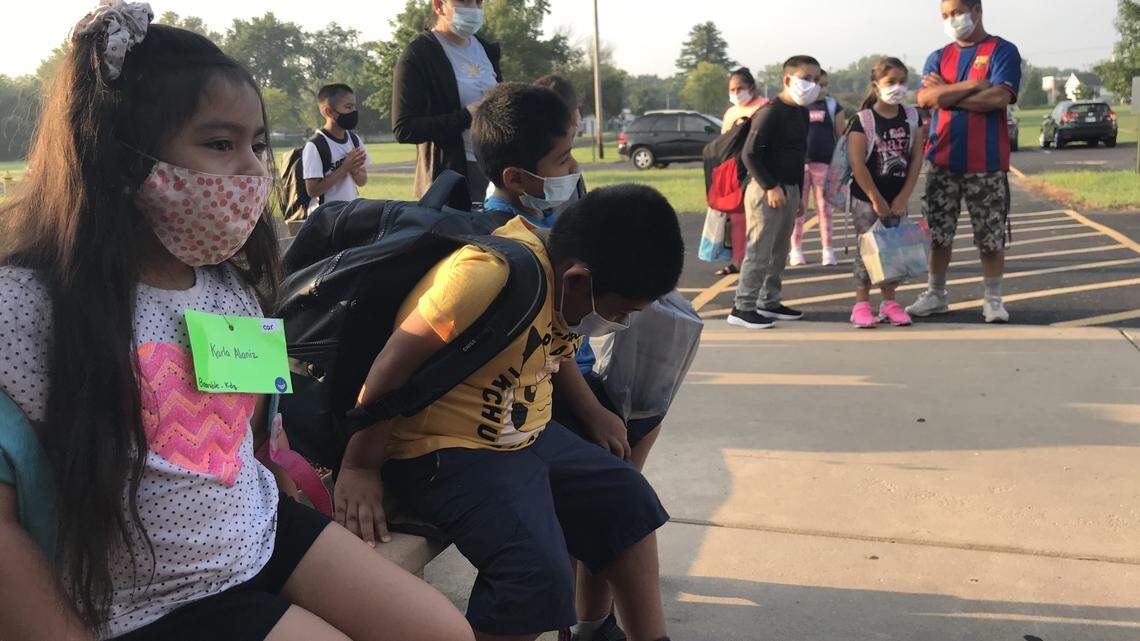 Karla Alanez, left to right, Sebastian Garcia and Angel Garcia wait for the doors to open at Kreitner Elementary School in Collinsville on Wednesday.