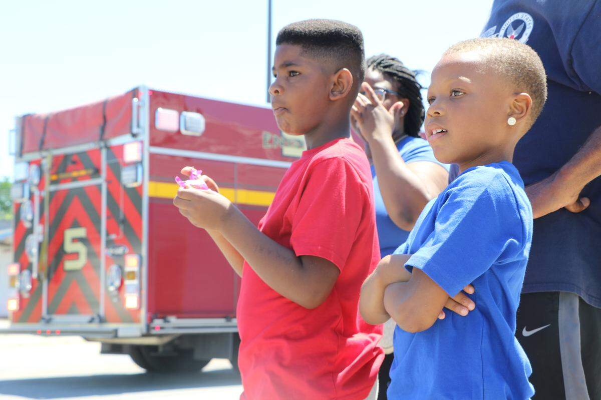 Dakari Jefferies and Jevon Gibson, both 7, watch the Juneteenth motorcade pass through East St. Louis Saturday.