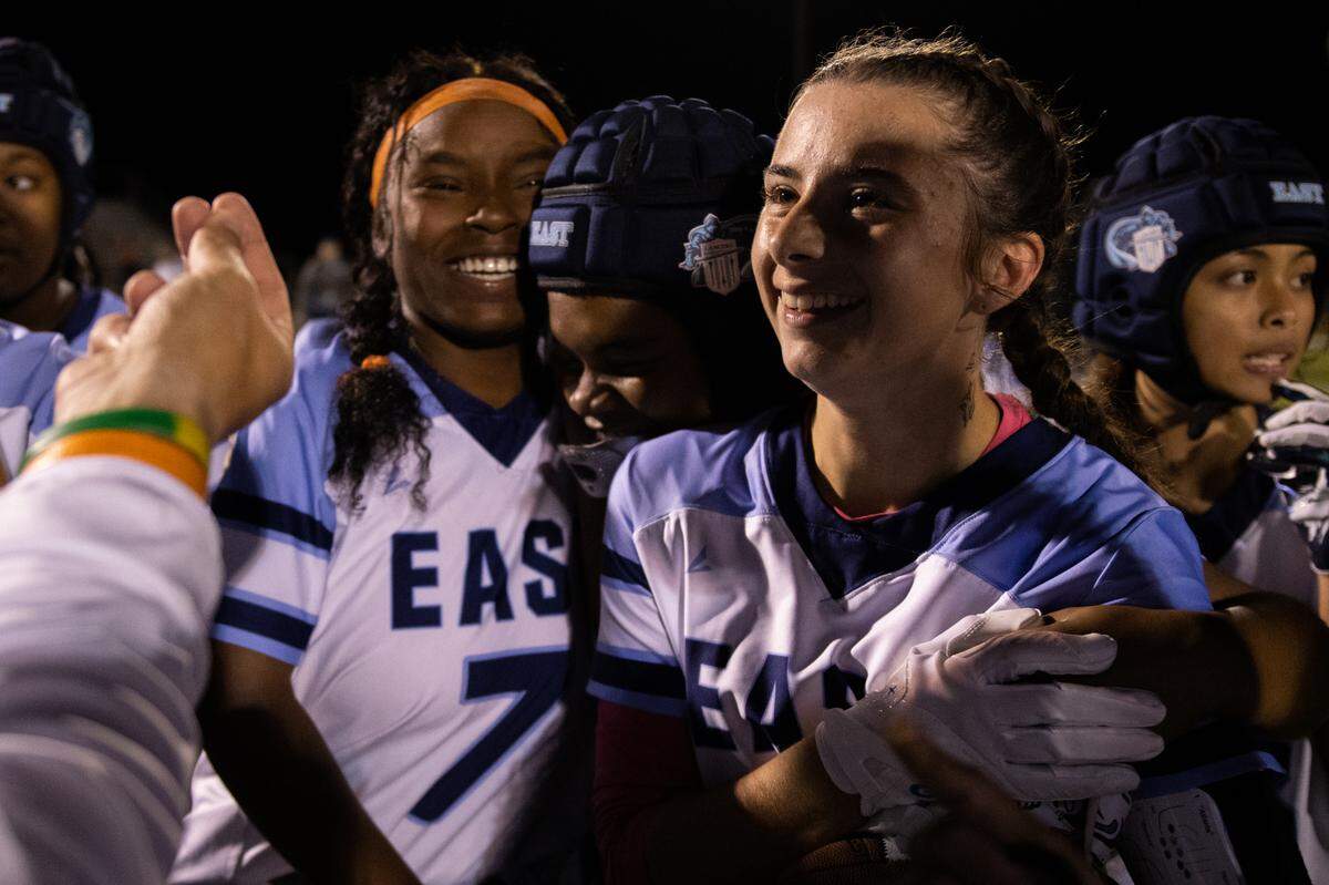 Belleville East’s Ary Kohler (2) holds onto her teammates after scoring a game-winning touchdown against Belleville West on Wednesday.
