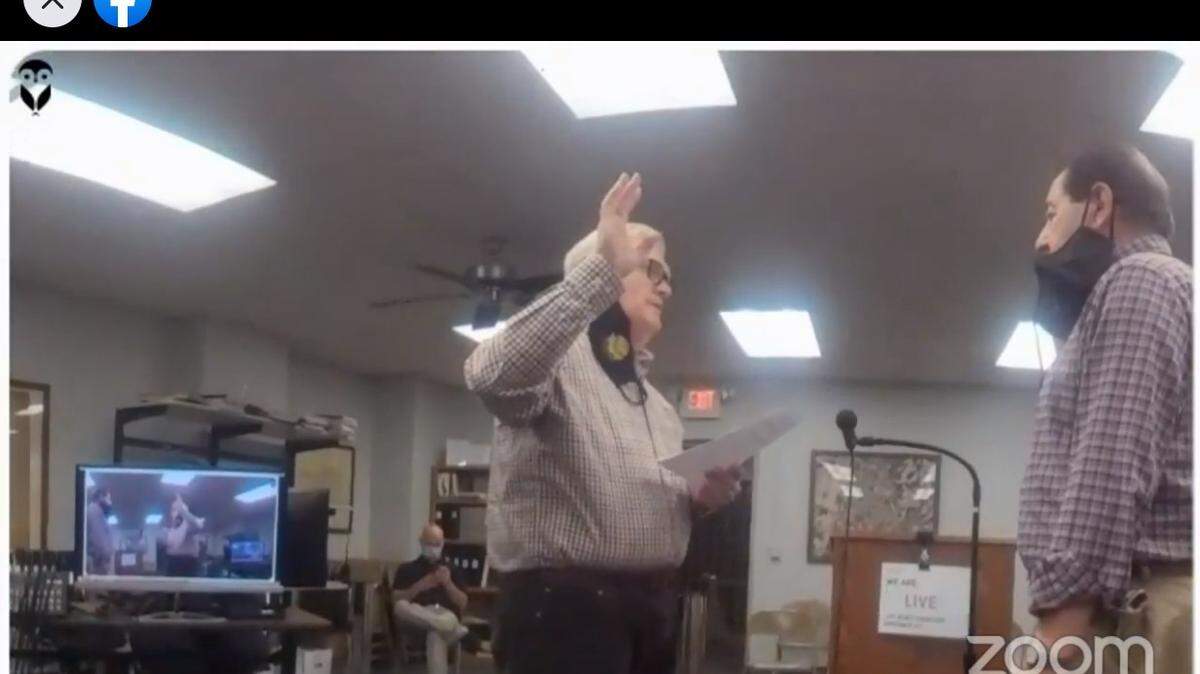 Columbia City Clerk Wesley Hoeffkin, left, is shown swearing in Ward 3 Alderman Gene Ebersohl as acting mayor on Wednesday night at a special meeting streamed live on Facebook.