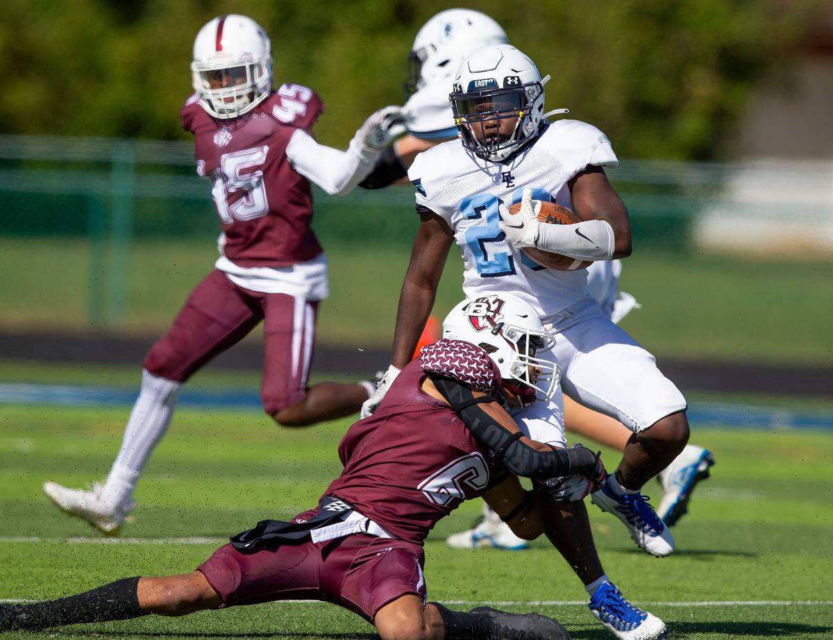Belleville East’s Moisey Trimble carries the ball while under pressure during Saturday’s Southwestern Conference game against Belleville West. The Lancers ultimately prevailed 41-0.