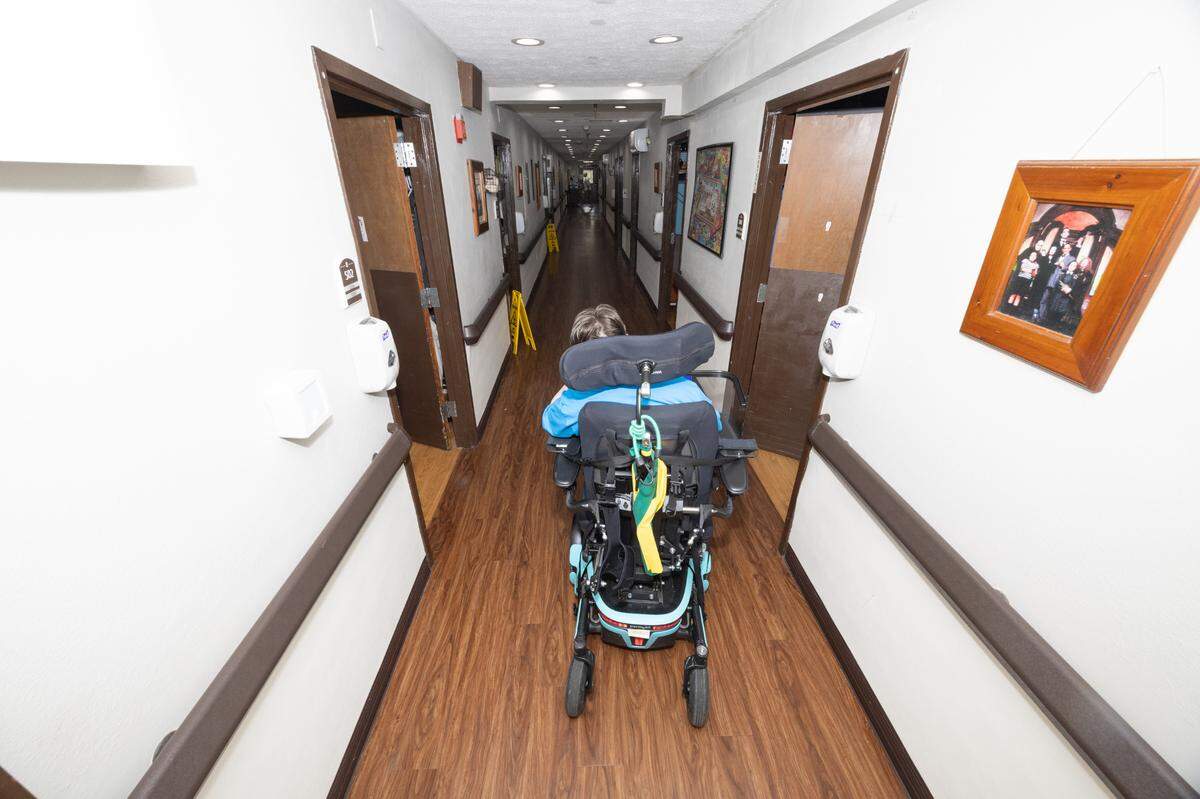 Jennifer Foushee travels down a hallway of Clinton Manor Living Center on the way to her room. Foushee has been speaking out about possible cuts to Medicaid and how they could affect her and her friends at Clinton Manor.