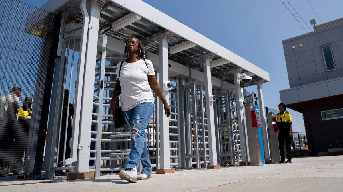 Pamica Isom, 52, of St. Louis, exits a newly installed turnstile on Monday, Sept. 9, 2024, at the Emerson Park Metro stop in East St. Louis. “I think [the turnstiles] are great because some of the things that have been going on the Metro,” she said. “Everyone just wants to feel safe.”