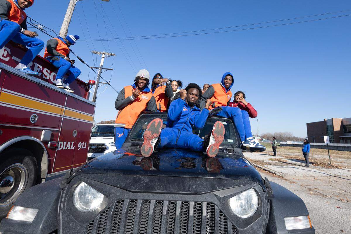 Members of the Flyers football team piled onto cars to roll down State Street as part of the East St. Louis victory parade.