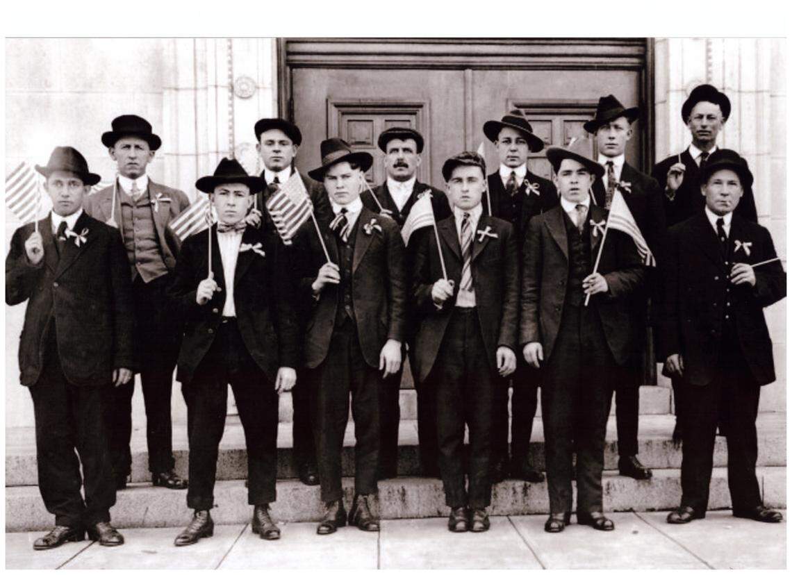 The accused mob leaders pose with American flags outside of the Madison County courthouse in Edwardsville. Joseph Riegel is in the back row, second from the left.