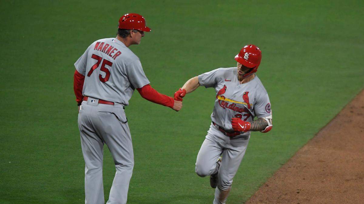 St. Louis Cardinals’ slugger Tyler O’Neill (27) is congratulated by third base coach Ron Warner after hitting a two-run home run against the San Diego Padres last season. How much were O’Neill and his teammates afforded for meals while on the road? And how much do they get with this year’s new Collective Bargaining Agreement?