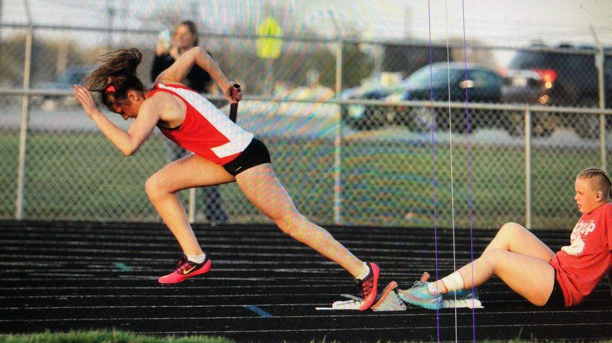 Senior Alyssa Freimann blasts off the starting block to open Highland's 4 x 400-meter relay team which went on to win the event at the Steve Moore Invitational Thursday at HHS. Senior McKenzie Nigh is holding the block for Freimann, who earned four medals to help the Lady Bulldogs win the team title of their own invite.