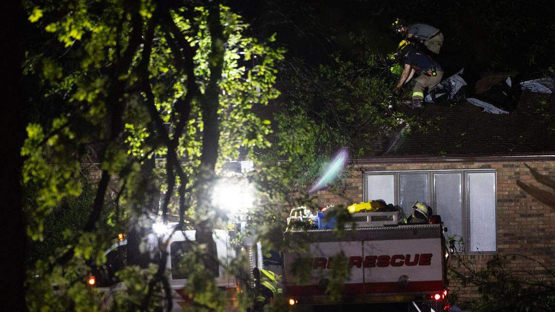 Fire crews check a house along IL 160 between Trenton and New Baden, where a likely tornado damaged homes and downed power lines Monday.