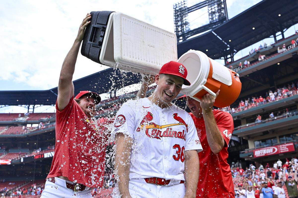Jul 31, 2024; St. Louis, Missouri, USA;  St. Louis Cardinals starting pitcher Michael McGreevy (36) is doused with water by pitcher Miles Mikolas (left) and pitcher Kyle Gibson (right) after winning his first MLB game in his Major League Debut against the Texas Rangers at Busch Stadium. Mandatory Credit: Jeff Curry-USA TODAY Sports