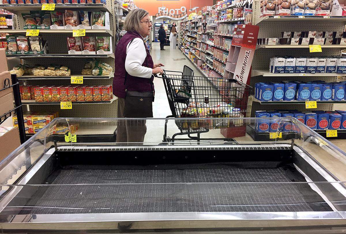 Sue Bald of Freeburg rolls her cart past an empty case Thursday at Tom's Market in Freeburg. Some shelves were showing signs of stock being depleted at the store. "I don't like to drive to Belleville for everything. I do my regular shopping here," said Bald.