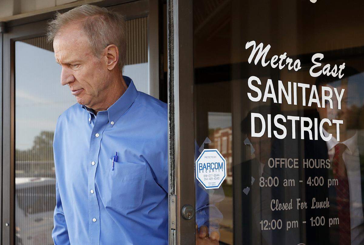 Illinois Gov. Bruce Rauner walks out of the Metro East Sanitary District building after his press conference Tuesday at the Granite City offices.