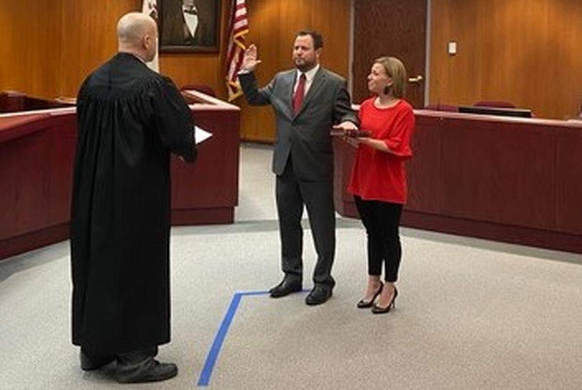 Circuit Judge Chris Hitzemann, left, swears in Ryan Webb Friday as an assistant state’s attorney in Monroe County. Webb will become the county’s top prosecutor on Feb. 28 when State’s Attorney Lucas Liefer and Assistant State’s Attorney Jennifer Becker-Roscow are sworn in as associate judges in the 24th Judicial Circuit. Webb is accompanied by his wife, Cara.
