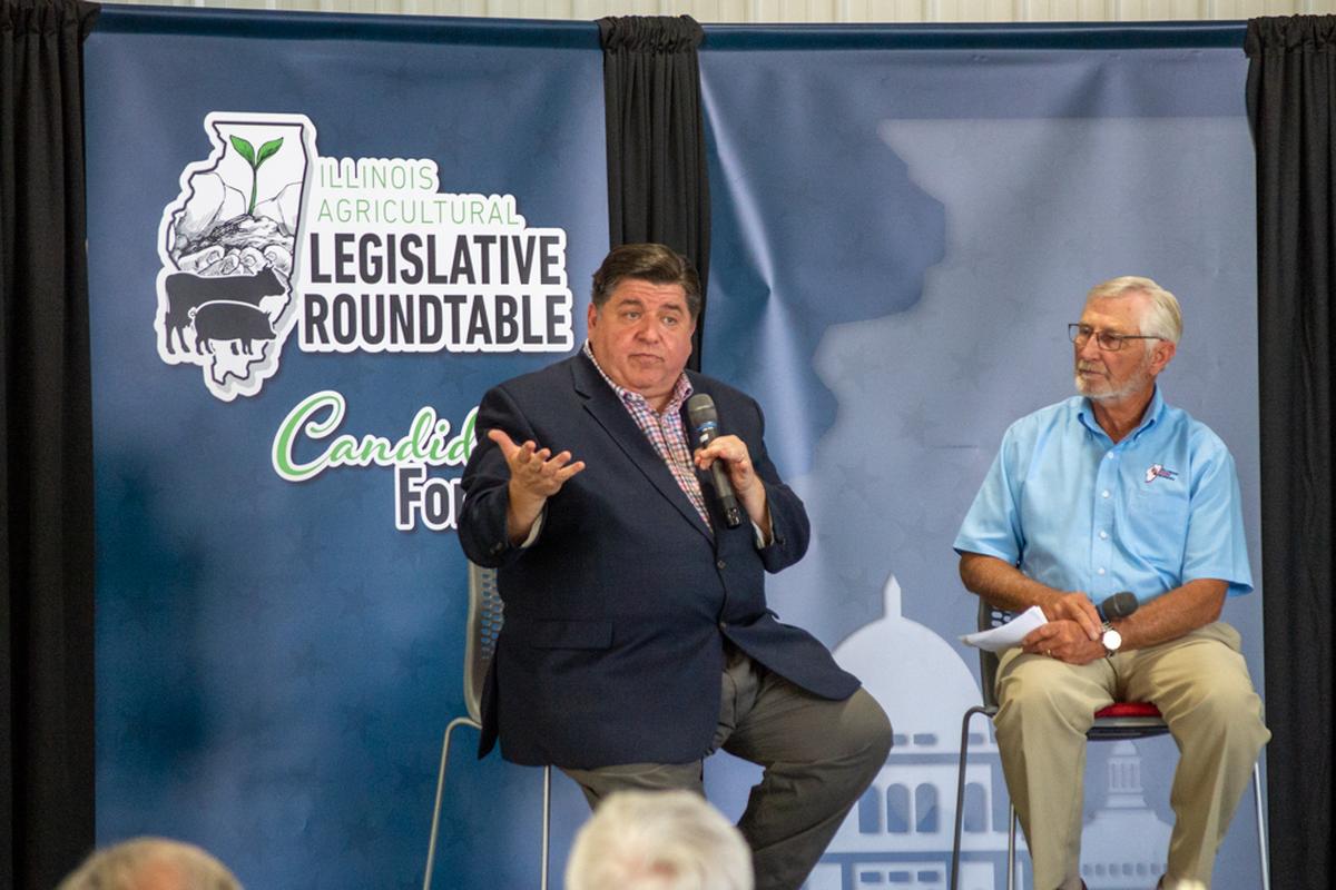 Gov. JB Pritzker talks during a legislative roundtable on a McLean County farm near Lexington. Illinois Farm Bureau President Richard Guebert Jr. (right) moderated the event.