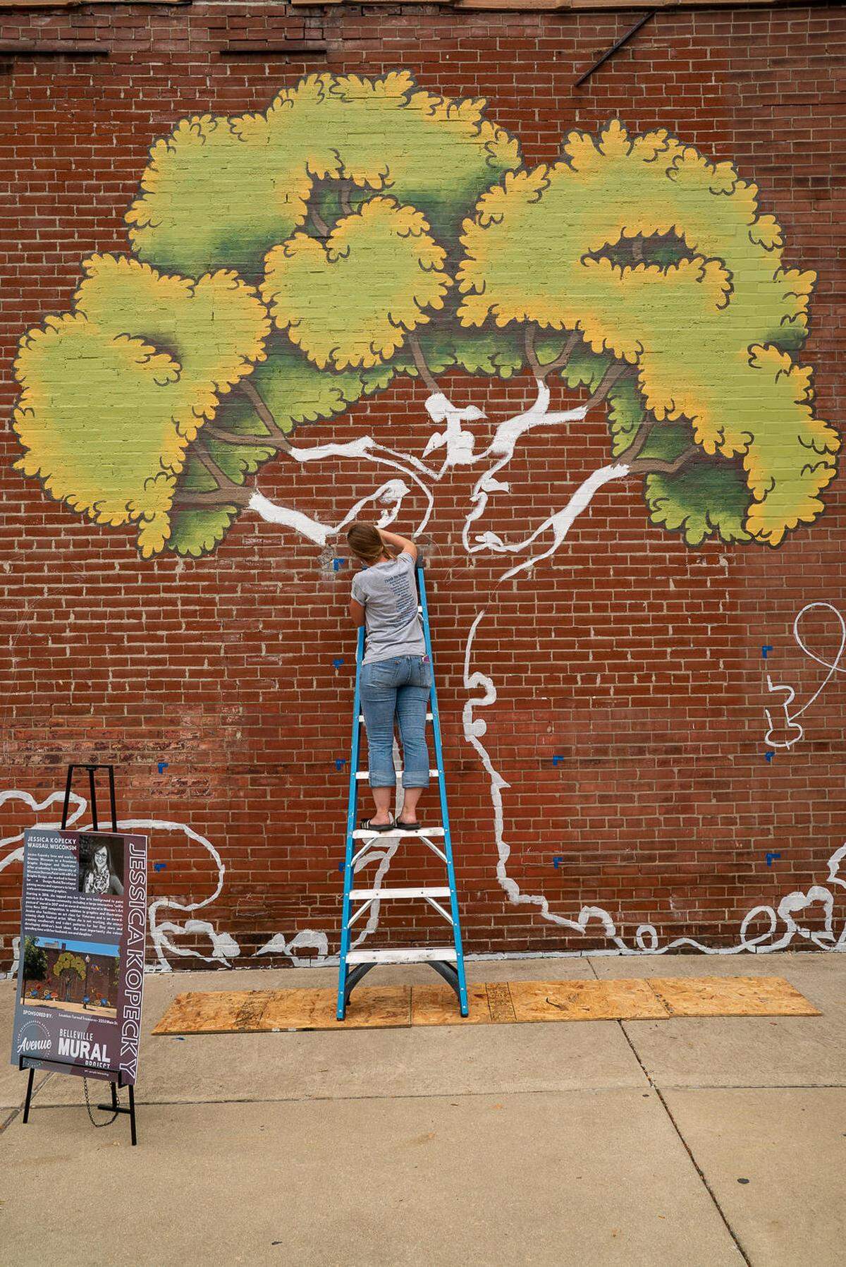 Jessica Kopecky works on the tree that is the centerpiece of her mural on Sept. 28.