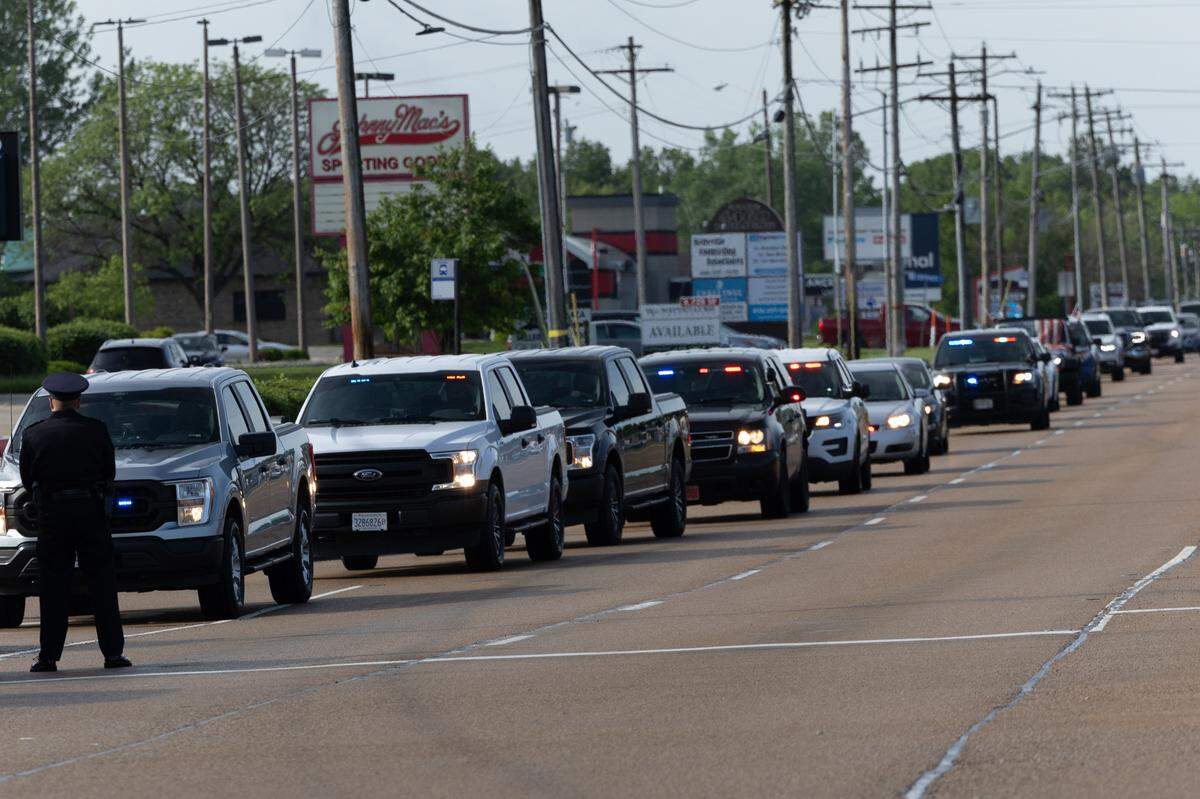 A police officer directs traffic while standing at ease during a memorial service for fallen police officers of St. Clair County in Christ Church on Frank Scott Parkway in Fairview Heights, Ill. on May 7, 2024.