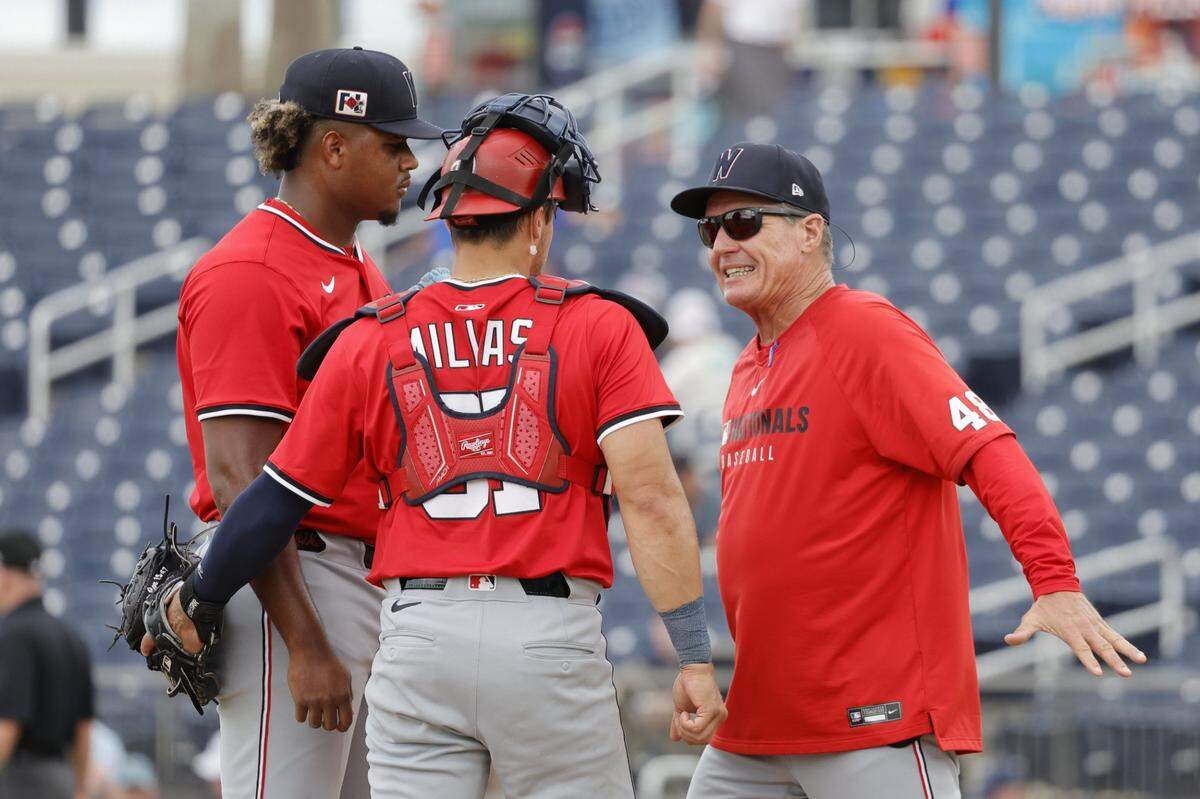 Feb 22, 2025; West Palm Beach, Florida, USA; Washington Nationals pitching coach Jim Hickey (48) and catcher Drew Millas (81) meet at the mound with pitcher Jarlin Susana (left) in the sixth inning against the Houston Astros at CACTI Park of the Palm Beaches. Mandatory Credit: Reinhold Matay-Imagn Images