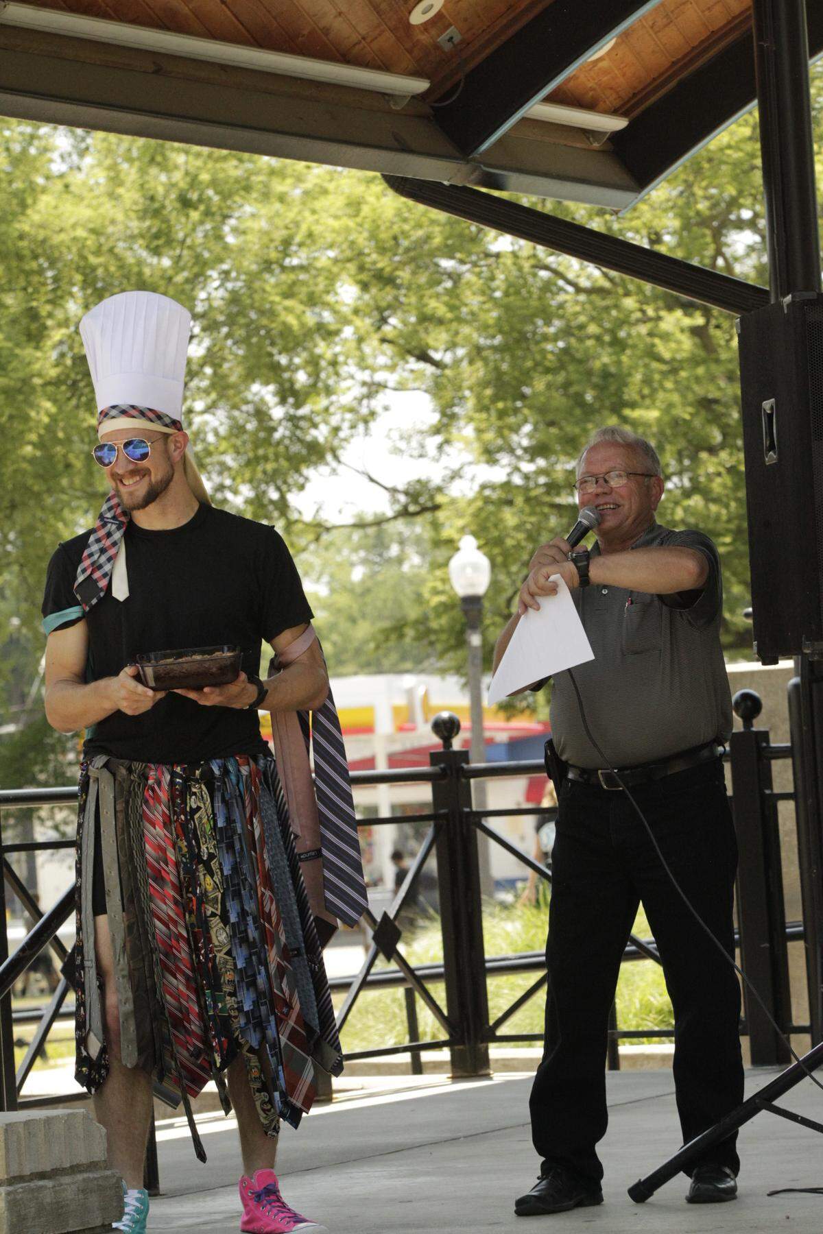 Auctioneer Virgil Straeter takes bids as Pastor Will VerDuin of Evangelical United Church of Christ shows off his "My Thai-Tie Pie" during the Celebrity Pie Auction in Highland.