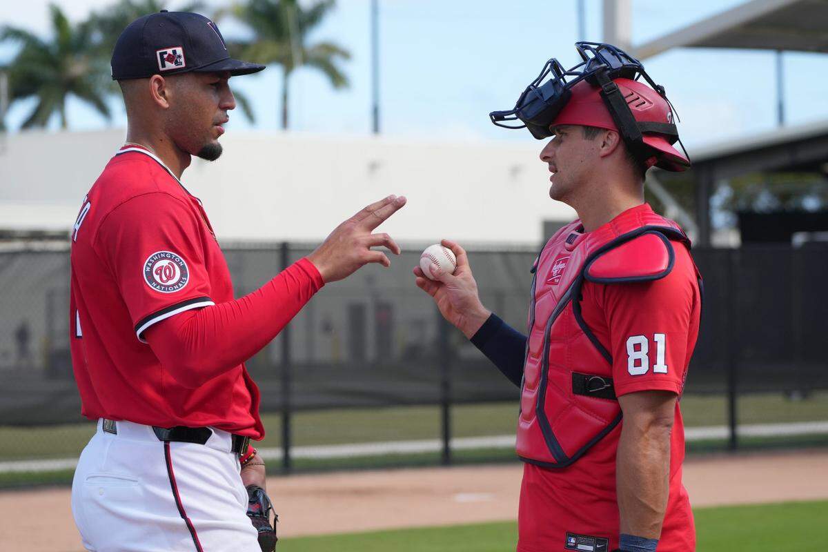 Feb 15, 2025; West Palm Beach, FL, USA;  Washington Nationals catcher Drew Millas (81) and pitcher Orlando Ribalta (64) talk after a bullpen session at Spring Training. Mandatory Credit: Jim Rassol-Imagn Images