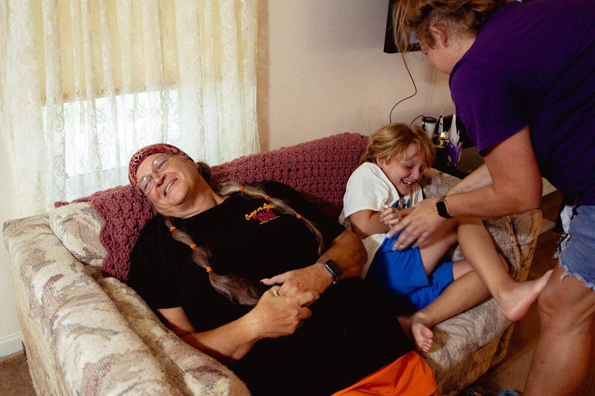 Tina Weber speaks with her mother about pain associated with diverticulitis as her daughter Samantha Bloodworth, right, tickles her son Christian, 8, on Saturday, July 27, 2024, at their home in Imperial, Missouri.
