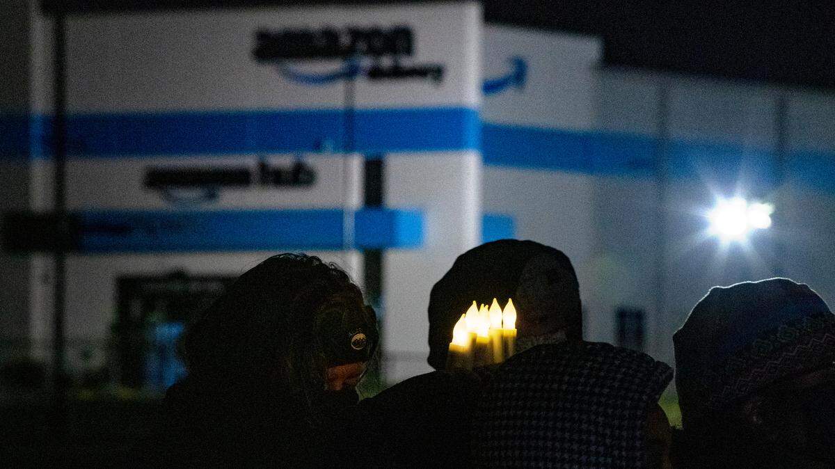 A person holds six electric candles symbolizing the six worker who died while working at an Edwardsville Amazon site that collapsed due to a tornado last week. Family and friends attended the vigil that featured several activists and lawmakers calling for Amazon to be held accountable for the tragedy.