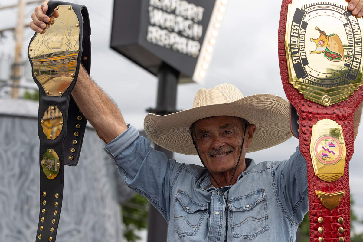 Owner of Big Texan Steak Ranch holds up title belts owned by Kyle “The Hammer” Hanner, a Wood River-based competitive eater with a resumé full of championships.