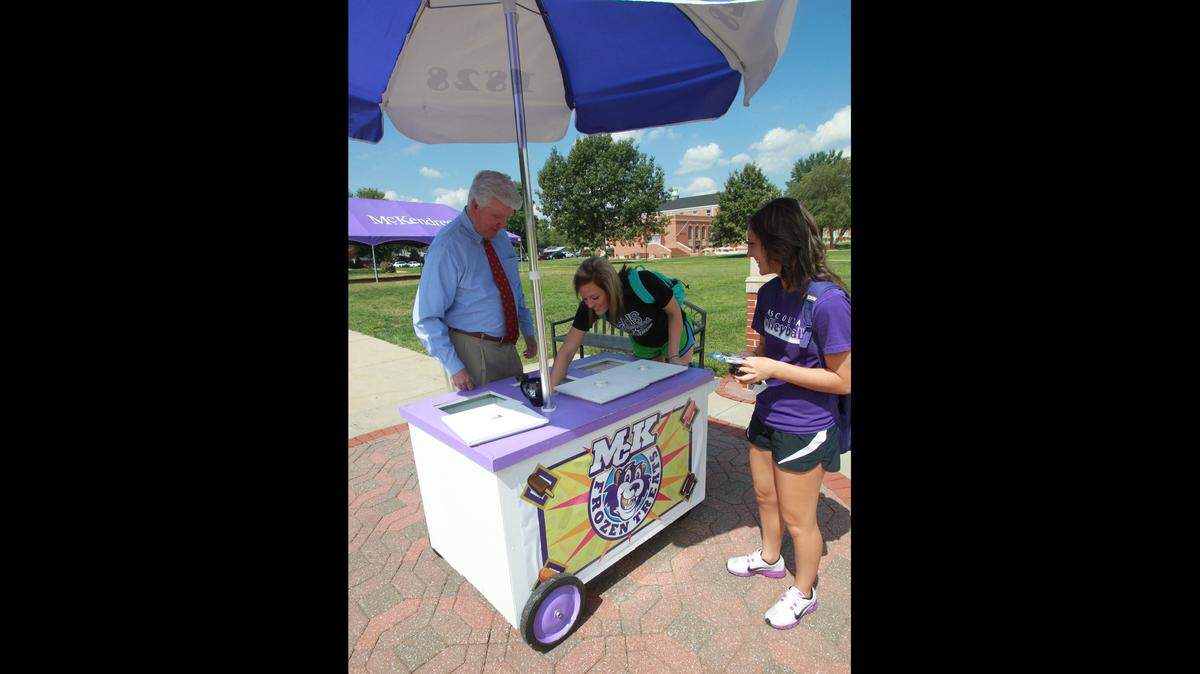 McKendree University President James Dennis, left, allows students Taylor Voss, center, and Laura Biekert to pick out their favorite ice-cream treats on a hot day in 2012.
