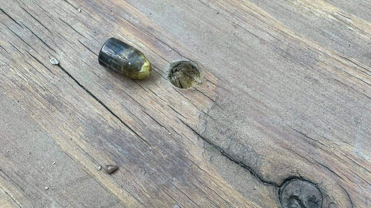A 9mm bullet rests alongside the hole it created in the backyard deck of Swansea residents Tim and Micah Sexton. Police believe the bullet may have been fired into the air from up to three miles away.