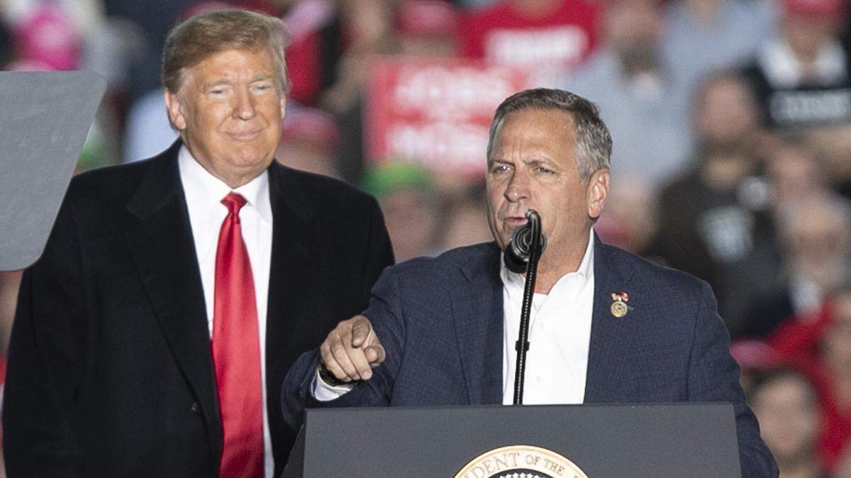 President Donald Trump listens as Congressman Mike Bost talks at a Make America Great Again rally in Murphysboro.