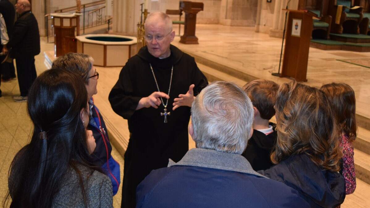 The Rev. Godfrey Mullen, center, meets with Catholic members of the Diocese of Belleville on Friday following a news conference announcing he’ll become their 10th bishop.