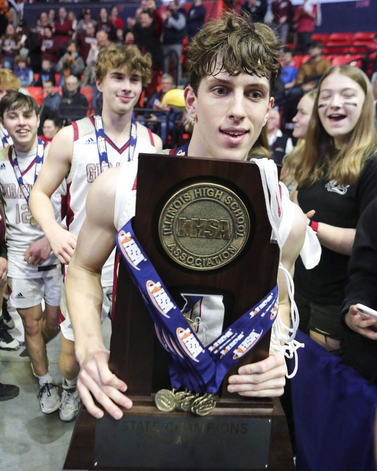 Gibault’s Kameron Hanvey takes the championship trophy to the fans after Saturday’s IHSA Class 1A state championship game against Scales Mounds at the State Farm Center on the campus of University of Illinois. Gibault ultimately prevailed 65-45 to claim the state title.