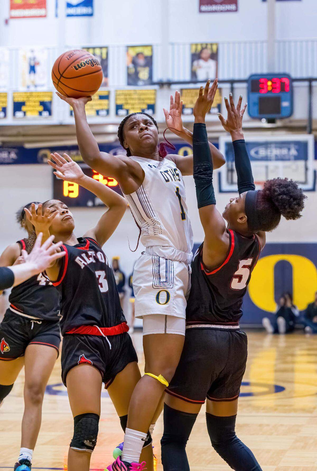 O’Fallon Jailah Pelly shoots the ball between two Alton defenders during the IHSA Class 4A O’Fallon Sectional semifinals. The Panthers ultimately prevailed 49-43.