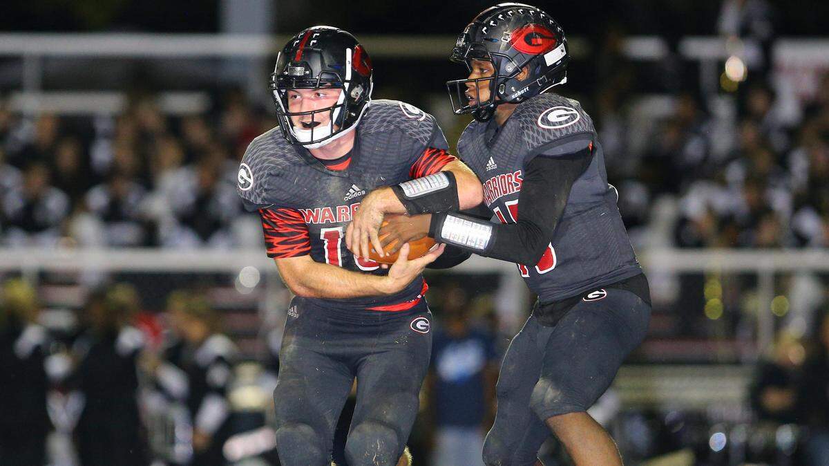 Logan Gordon takes a handoff from Freddy Edwards during Granite City’s win over Mater Dei, Oct 12. The Warriors went on to a 5-4 regular-season record and their first playoff berth since 2009.