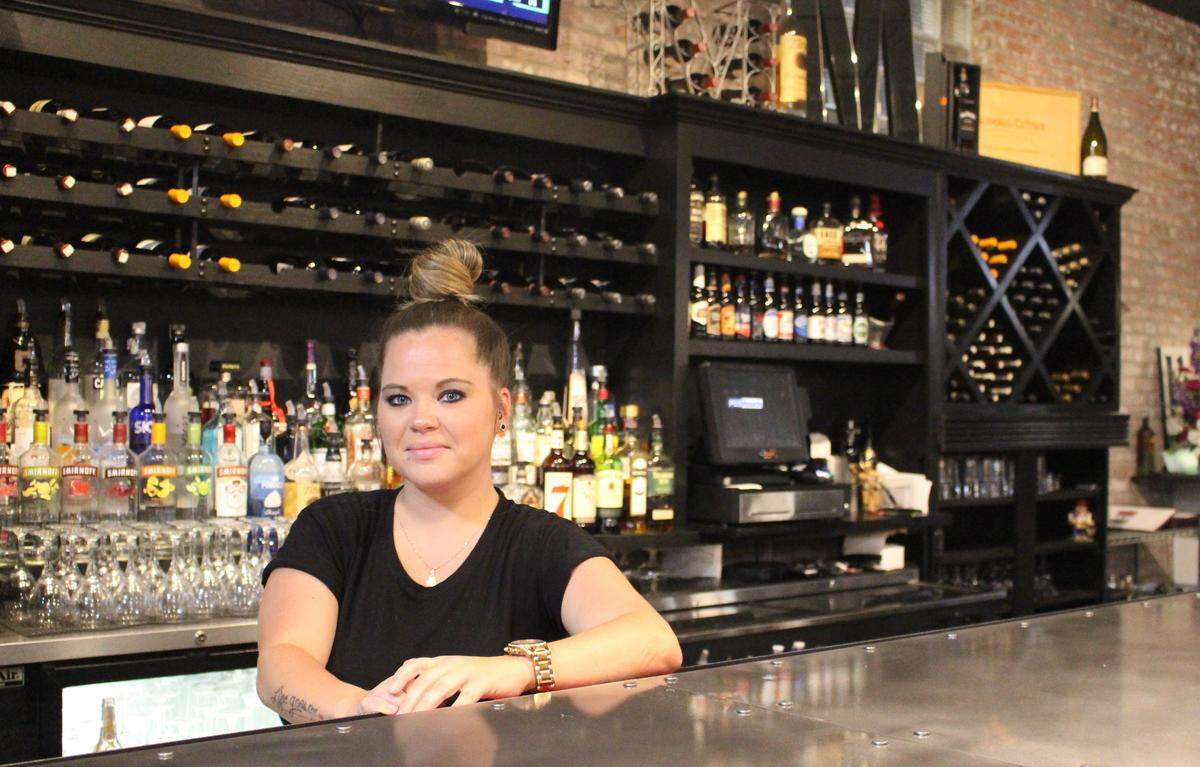 Bartender Brittnay Juenger serves drinks at Mungo’s Uptown, a new Italian restaurant in downtown Collinsville. Owner Tony Mazzola brought the wooden back bar from his former location in O’Fallon.