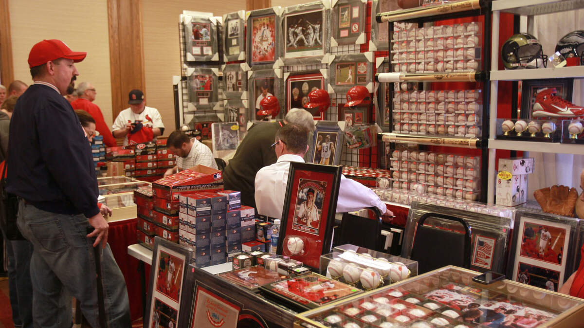 A St. Louis Cardinals fan looks over baseball memorabilia and other merchandise at a past Cardinals Winter Warm-Up at the Hyatt Regency at the Arch in downtown St. Louis. The annual event raises money for the Cardinals Care program, which is the team’s community foundation supporting kids. This year’s event has been canceled due to the MLB work stoppage.