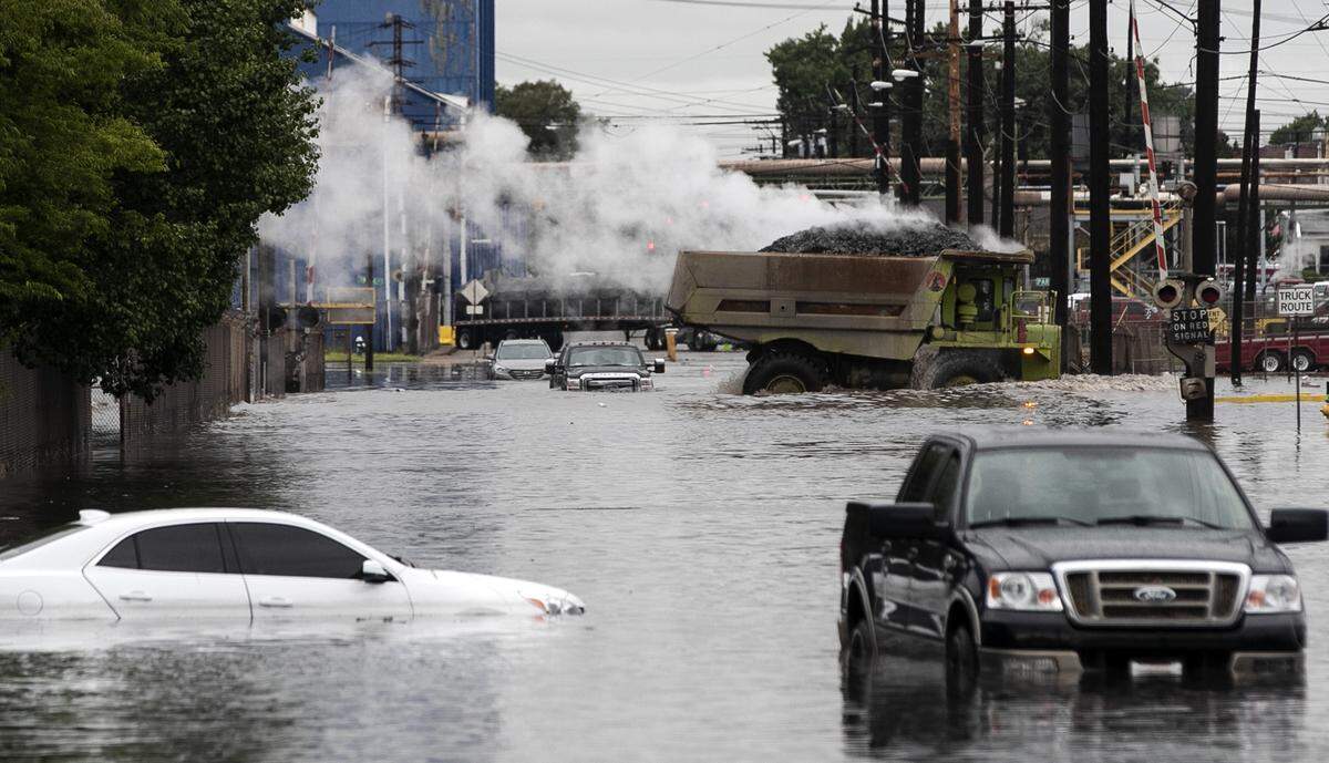 A U.S. Steel truck drives through the flooded East 20th Street in Granite City surrounded by stranded vehicles caught in the flash flooding.
