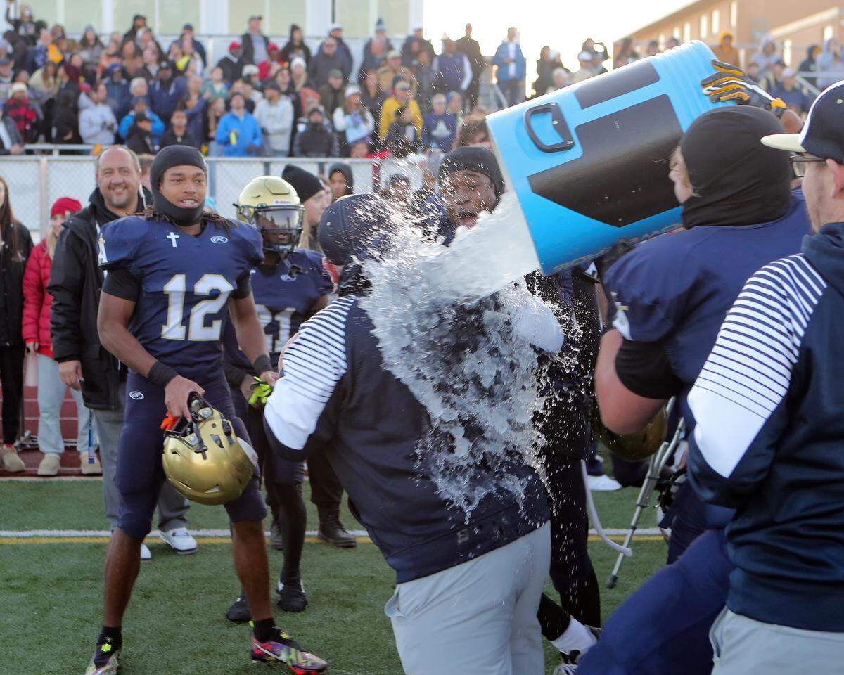 Althoff Head Coach Austin Frazier receives a celebratory ice bath from his players as the clock winds down on the IHSA Class 1A semifinal game against Camp Point (Central). The 58-19 win advances the Crusaders to the championship game next Friday at Illinois State University where they will face Lena-Winslow.