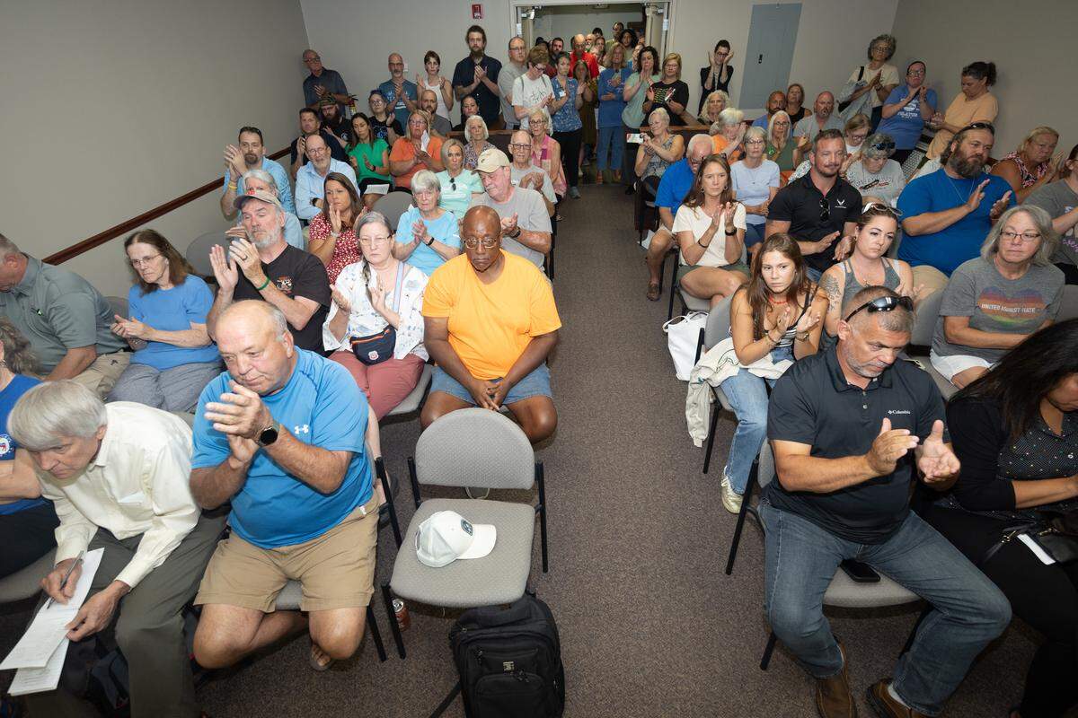 The crowd at a Clinton County Board meeting on Monday night erupts into applause after board members unanimously voted for a non-binding resolution condeming all forms of racism and bigotry in the county.