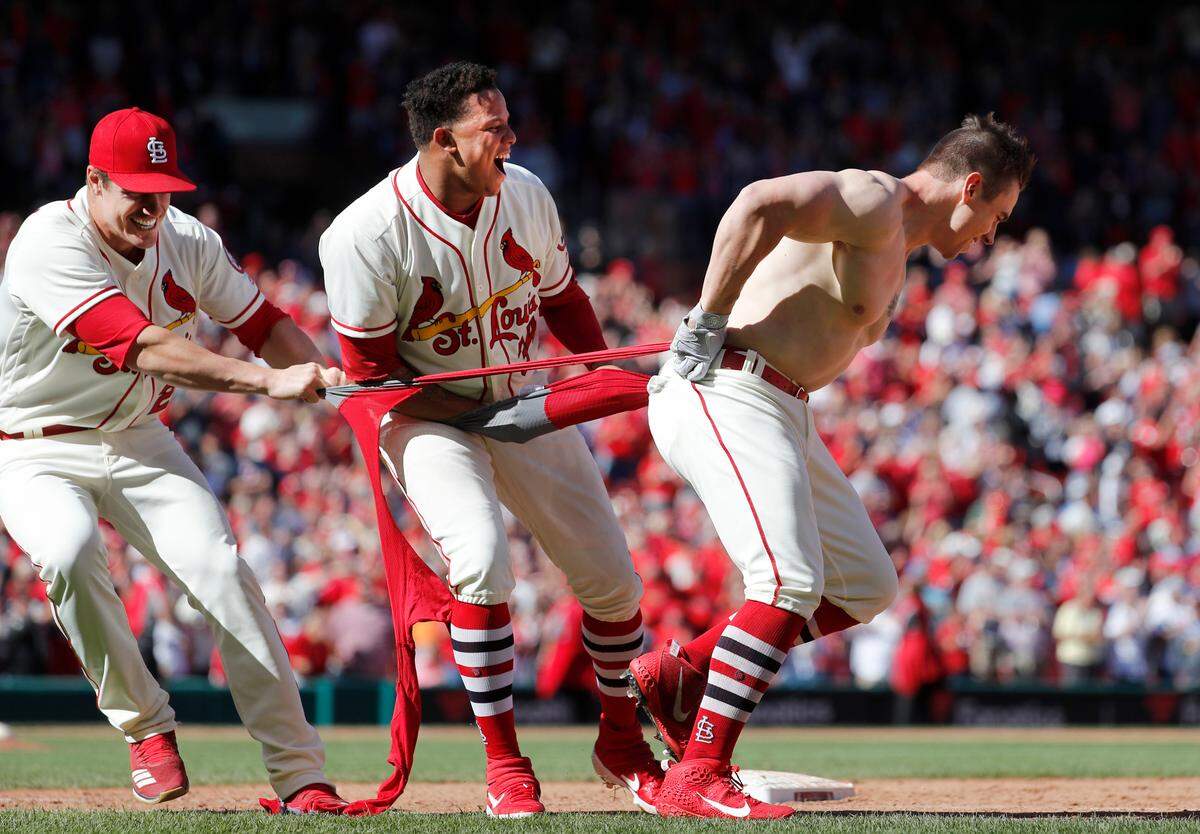 St. Louis Cardinals’ Tyler O’Neill has his jersey ripped off by teammates Yairo Munoz, center, and Patrick Wisdom, left, after O’Neill hit a walk-off home run to defeat the San Francisco Giants 5-4 in the 10th inning of a baseball game Saturday, Sept. 22, 2018, in St. Louis. (AP Photo/Jeff Roberson)